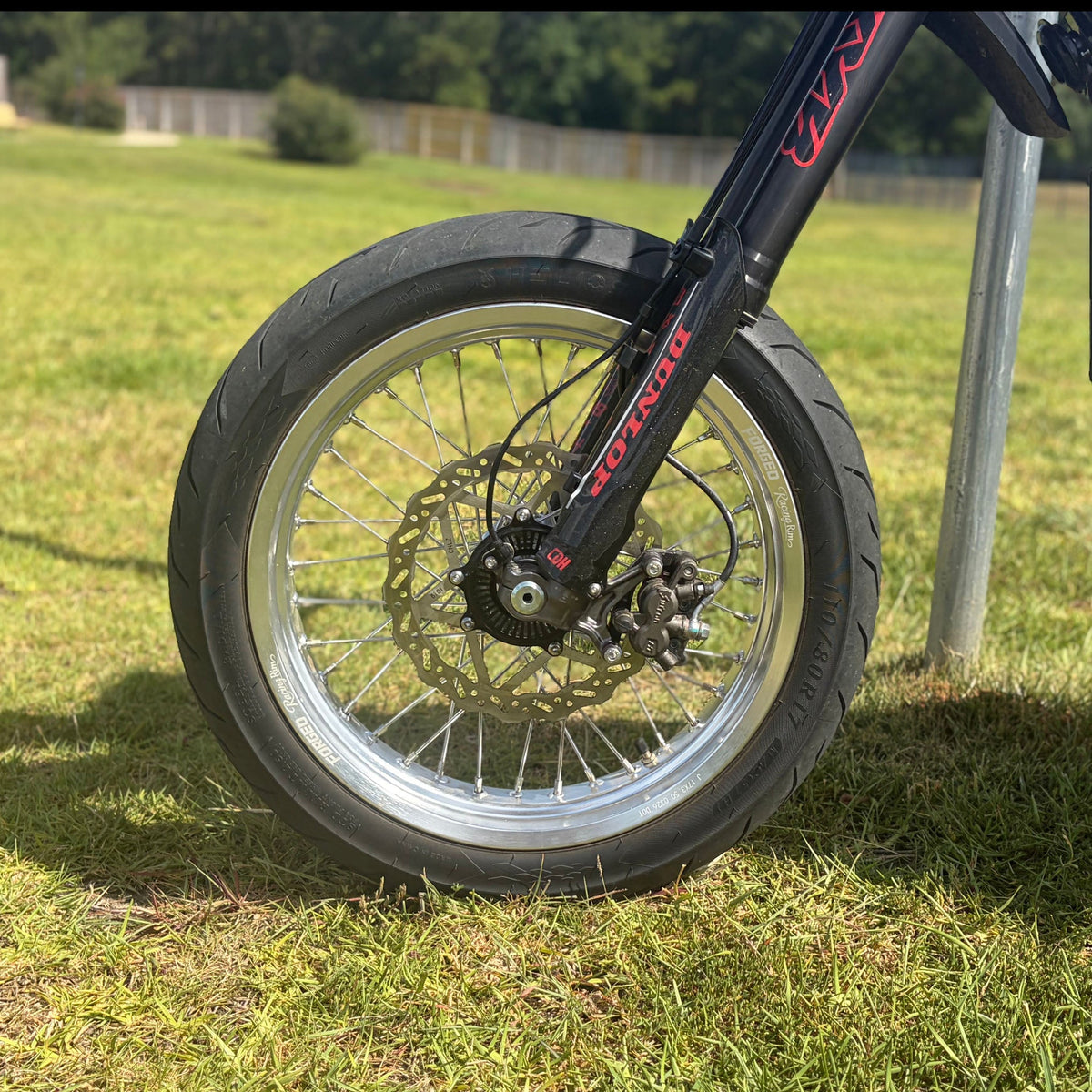 Sur-Ron Ultra Bee 17-inch supermoto wheel set in black and chrome finish - close-up detail