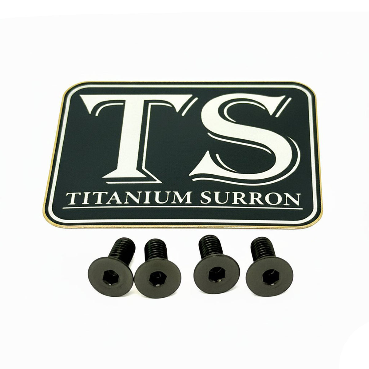 A black rectangular metal badge with rounded corners featuring the white stylized letters 'TS' and the text 'TITANIUM SURRON' below, shown with four black hex-head screws on a plain white background.