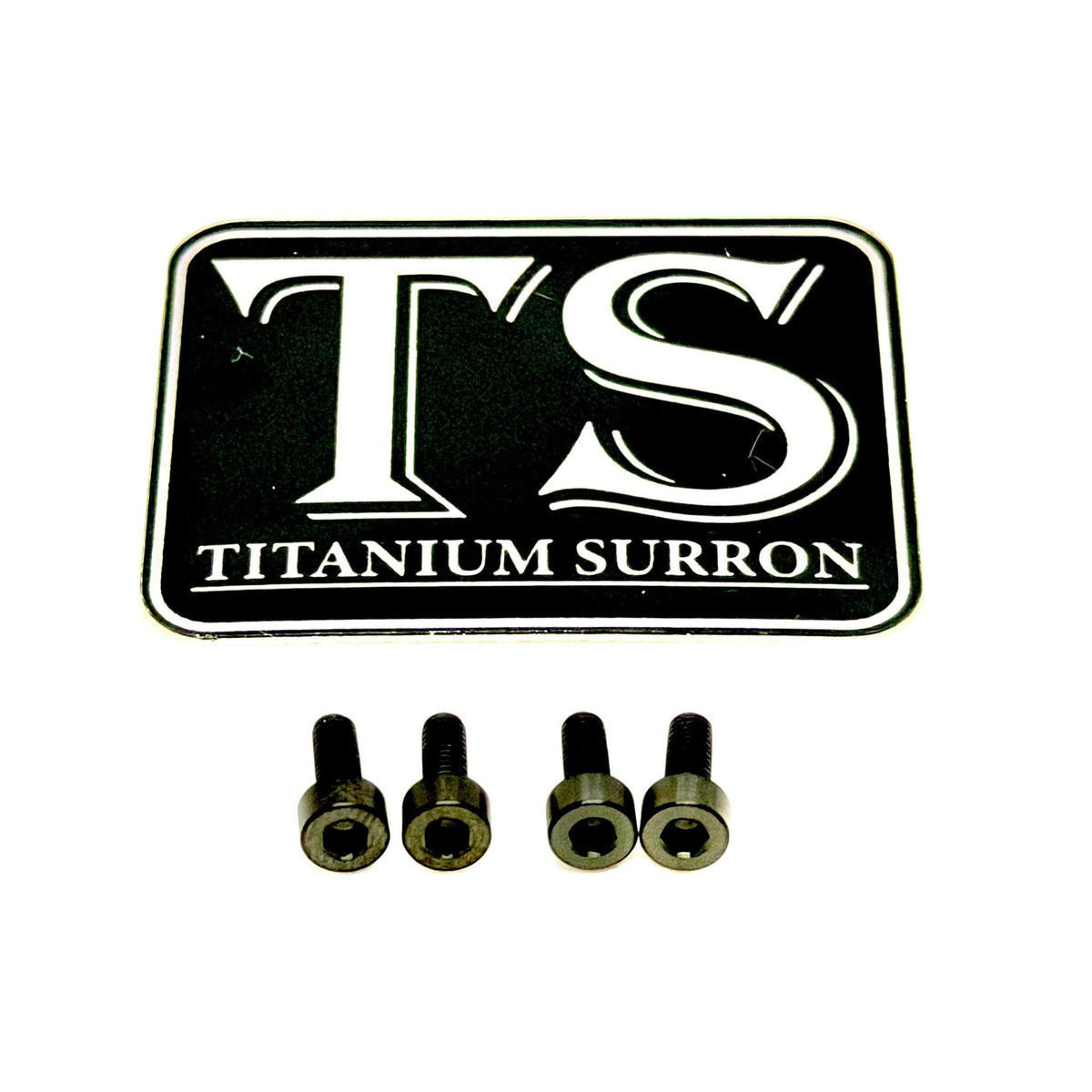 A black and white 'TS TITANIUM SURRON' emblem patch shown above four small metallic screws on a plain white background.