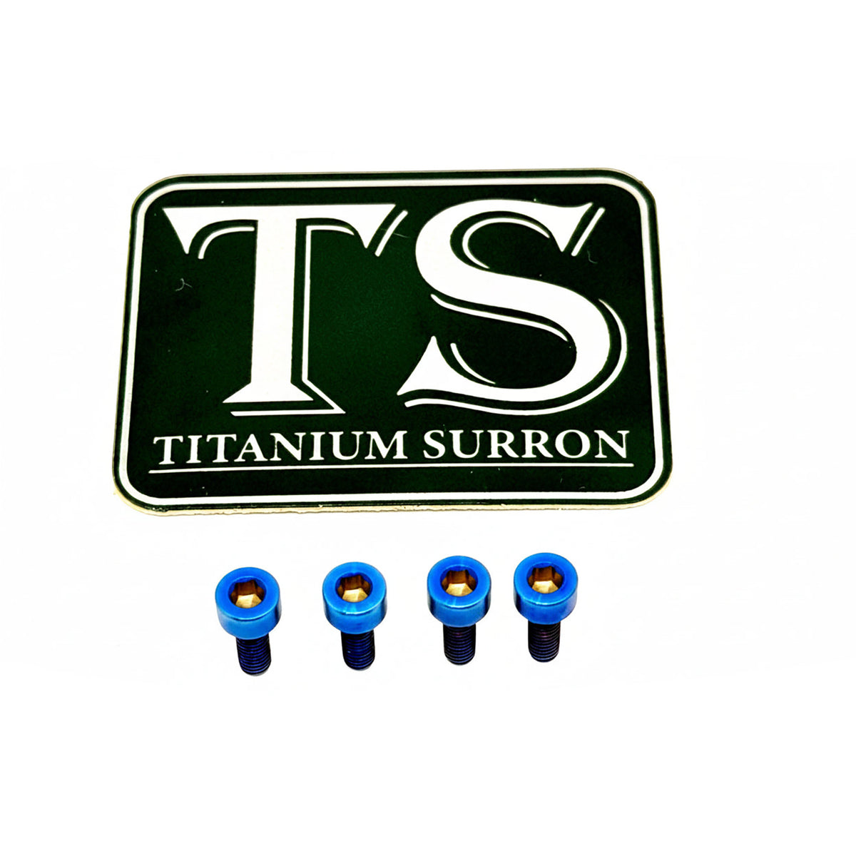 A black rectangular badge or emblem with rounded corners featuring large white 'TS' lettering and the words 'TITANIUM SURRON' below, shown above four small blue-and-black hardware pieces on a plain white background.