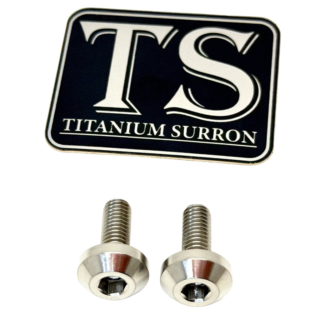 Two silver titanium surron screws shown below a black and silver TS Titanium Surron logo badge on a plain white background.