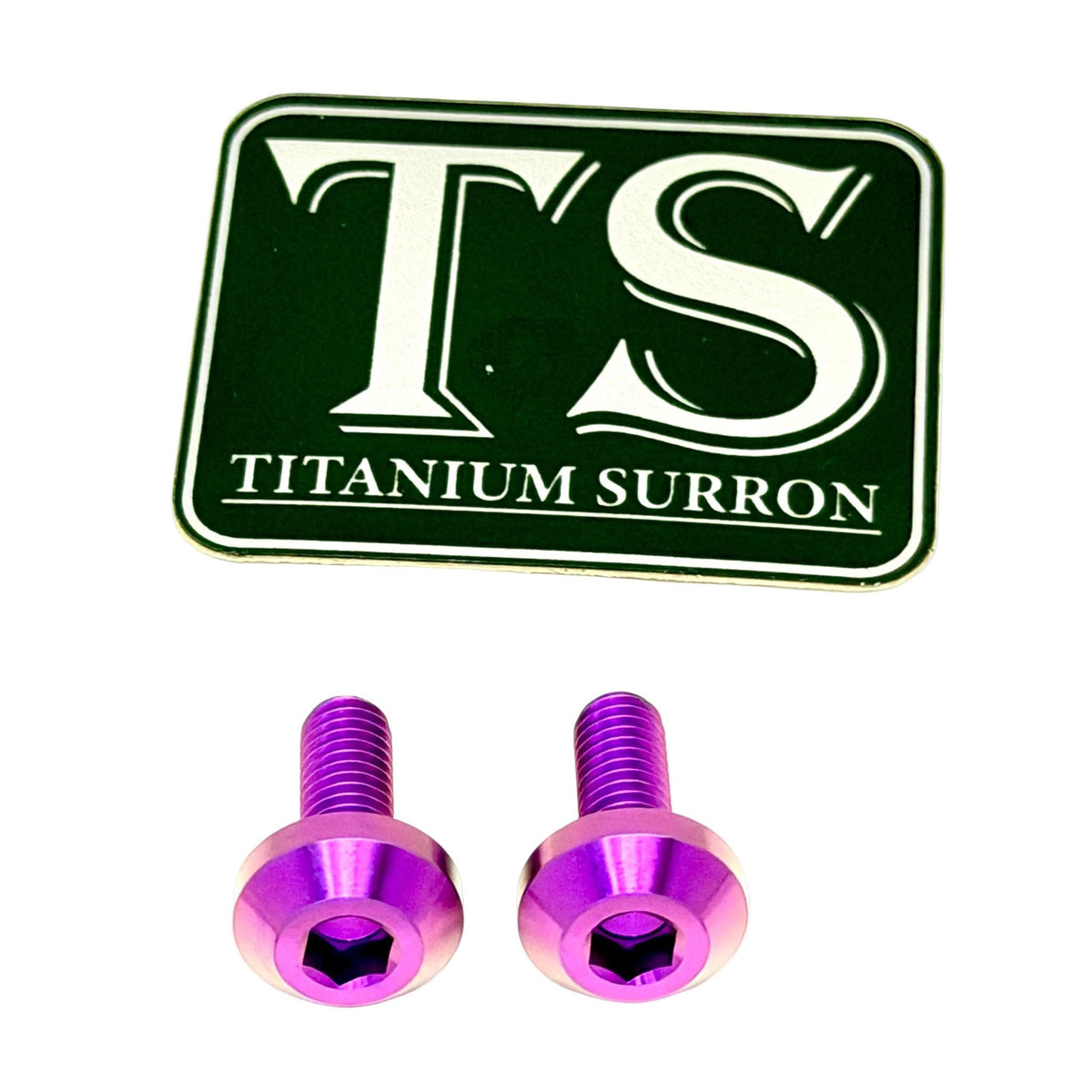Two purple anodized titanium hex head screws shown below a dark green rectangular badge with white 'TS' lettering and 'TITANIUM SURRON' text, on a plain white background.