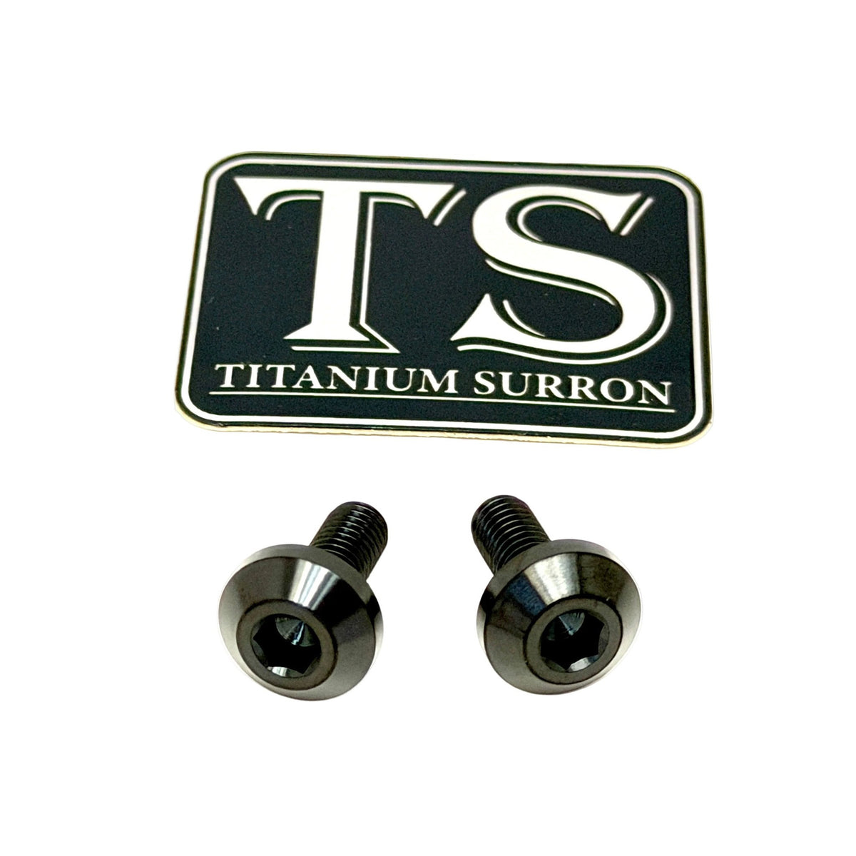 Two metallic screws with a cross-slash head and a black badge featuring the letters 'TS' and the text 'TITANIUM SURRON' on a white background.